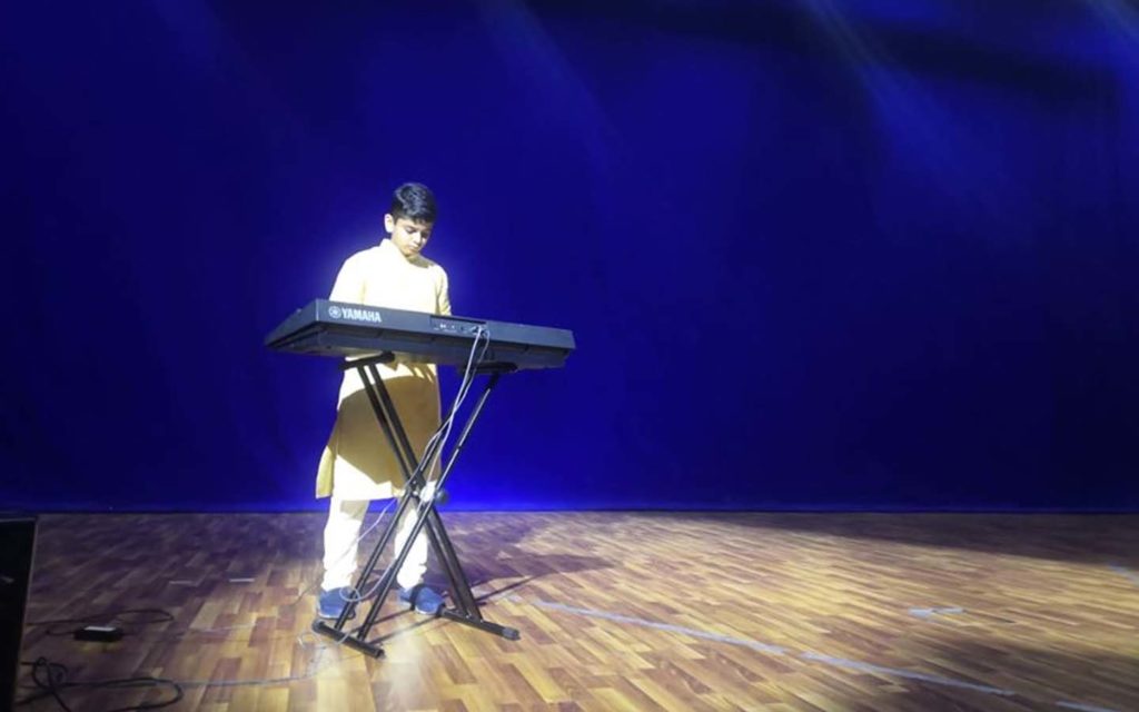 JSS International School student playing piano as an extra-curricular activity