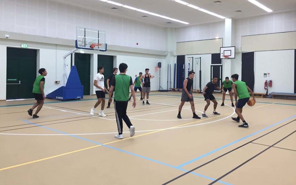 Students of Jumeirah College playing in a basketball court